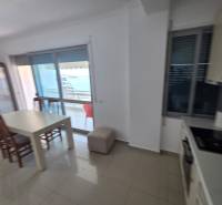 Sarandë - zariadený apartmán s otvoreným výhľadom na more - Jedálenský kút s výhľadom na more v rekreačnom apartmáne, svetlé interiérové zariadenie.