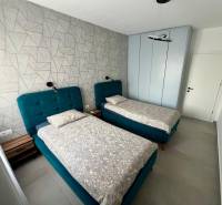 Sarandë - zariadený apartmán, výhľad na more, garážové státie - Dvojlôžková izba s modrými posteľami a vzorovanou stenou v Rekreačnom apartmáne.