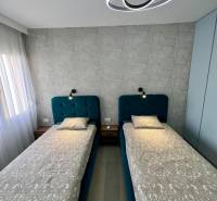 Sarandë - zariadený apartmán, výhľad na more, garážové státie - Dvojlôžková spálňa s geometrickou tapetou a moderným osvetlením v rekreačnom apartmáne.