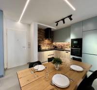 Sarandë - zariadený apartmán, výhľad na more, garážové státie - Kuchyňa v Rekreačnom apartmáne s jedálenským stolom, tehlovým obkladom a modernými spotrebičmi.