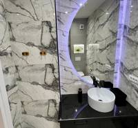Sarandë - zariadený apartmán, výhľad na more, garážové státie - Kúpeľňa v Rekreačnom apartmáne s okrúhlym zrkadlom a elegantnými obkladmi.