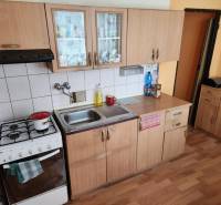 REZERVOVANÝ- 1-izbový byt, Košice, Ružová ulica - Kuchyňa v 1-izbovom byte s drevenými skrinkami a plynovým sporákom.