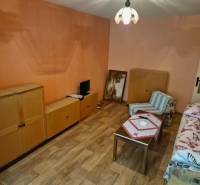 REZERVOVANÝ- 1-izbový byt, Košice, Ružová ulica - Izba s dreveným nábytkom a kreslom v 1-izbovom byte.