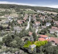 Dom pre náročného klienta, ktorý vie oceniť kvalitu –  Limbach - Pohľad na rodinné domy v Limbachu obklopené zeleňou a kopcami v pozadí.