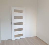 Nový moderný byt s balkónom a parkovaním v širšom centre. Jarabinková - Izba v 2-izbovom byte s bielymi dverami a svetlou podlahou.