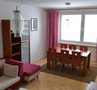 ‼️ 3 IZBOVÝ BYT NA PRENÁJOM, PARTIZÁNSKE-NÁDRAŽNÁ ULICA (ZARIADENÝ)‼️  - Jedálenský kút s dreveným stolom v 3-izbovom byte, doplnený ružovými závesmi a pohovkou.