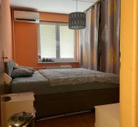 Predaj 3 izbový - Pezinok - Spálňa v 3-izbovom byte s manželskou posteľou, oranžovými stenami a klimatizáciou.