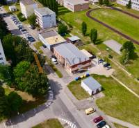 INVESTIČNÝ KOMERČNÝ OBJEKT | TOPOĽČANY  - Letecký pohľad na obchodné priestory na Janka Matušku v Topoľčanoch, obklopené bytovkami a športoviskom.