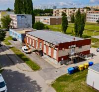INVESTIČNÝ KOMERČNÝ OBJEKT | TOPOĽČANY  - Ulica Janka Matušku v Topoľčanoch s budovami a parkoviskom, obchodné priestory v pozadí.
