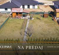 ÚTULNÁ CHATKA SO ZÁHRADOU | JACOVCE  - Záhrada s chatou obklopená stromami a skleníkom na ulici Jacovce na predaj.