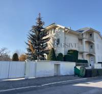 UBYTOVANIE PRE FIRMY - APARTMÁNY | TOPOĽČANY - Vila na Športovcov ulici v Topoľčanoch so stromami a odpadkovým kontajnerom.