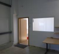 Sklad na prenájom s kanceláriami a zázemím o ploche 370 m2 - Dvere a stolík v interiéri skladov a hál, s poličkou na stene.