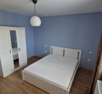 NOVÝ ZARIADENÝ BYT NA Muškáte - Spálňa v 2-izbovom byte s posteľou, šatníkom a drevenou podlahou.