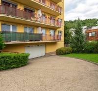 Veľmi pekný 4i byt 110m2, s klimatizáciou, 2x balkón a dvojgaráž - Výhľad na bytový dom so žltou fasádou a zelenou záhradou na Guothovej ulici.