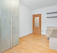 Veľmi pekný 4i byt 110m2, s klimatizáciou, 2x balkón a dvojgaráž - Izba v 4-izbovom byte s drevenou podlahou, posteľou a vstavanou skriňou.