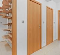 Veľmi pekný 4i byt 110m2, s klimatizáciou, 2x balkón a dvojgaráž - Predsieň s drevenými dverami, regálmi a vstupom do izby v 4-izbovom byte.