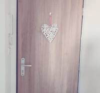 1-izb. apartmán, Antolska ul., Petržalka, rezidencia Draždiak - Drevené dvere s ozdobným srdcom a biely strop v 1-izbovom byte.
