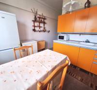 REZERVOVANÝ 2 IZBOVÝ TEHLOVÝ BYT, BALKÓN, ŠIRŠIE CENTRUM, PREŠOV - Kuchyňa v 2-izbovom byte s oranžovou linkou, bielou chladničkou a jedálenským stolom.