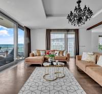 Predaj, Luxusný 4 izbový byt, 180 m2 + 25 m2, Condominium Renaissance - Štýlová obývačka v 4-izbovom byte so sedačkou, lustrom a výhľadom na terasu.