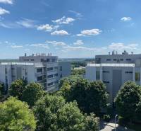 Predaj, Luxusný 4 izbový byt, 180 m2 + 25 m2, Condominium Renaissance - Pohľad na moderné bytovky v Bratislave - Karlovej Vsi obklopené zeleňou a modrou oblohou.