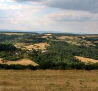Pozemok (3,1ha) na Hrušove okr. Veľký Krtíš s panoramatickým výhľadom. - Kopcovitá krajina s lesmi a otvorenými pozemkami, ideálne pre bývanie na vidieku.