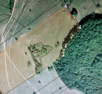 Pozemok (3,1ha) na Hrušove okr. Veľký Krtíš s panoramatickým výhľadom. - Letecký pohľad na pozemok obklopený lesom, ideálny na bývanie a investície.