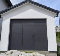 ‼️ NOVO POSTAVENÝ RODINNÝ DOM  S GARÁŽOU NA PREDAJ, MALÉ KRŠTEŇANY  ‼️ - Rodinný dom v Malých Krštenanoch s bielou garážou a tmavými dverami.