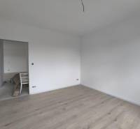 ‼️ NOVO POSTAVENÝ RODINNÝ DOM  S GARÁŽOU NA PREDAJ, MALÉ KRŠTEŇANY  ‼️ - Prázdna izba s bielymi stenami a svetlou drevenou podlahou v rodinnom dome.