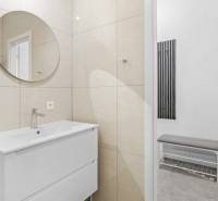 Moderný, zrekonštruovaný 3i byt 68m2, s lodžiou, pivnicou a parkovaním - Kúpeľňa v 3-izbovom byte s okrúhlym zrkadlom a bielym umývadlom.