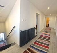 Dvojgeneračný RD, Bystré, pozemok 830 m², 3D - Chodba s farebným kobercom a schodiskom v rodinnom dome.