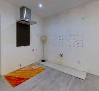 Dvojgeneračný RD, Bystré, pozemok 830 m², 3D - Prázdna kuchyňa v rodinnom dome s digestorom, bielymi stenami a farebnými kobercami.