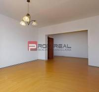 Predaj 3i, 74m2 bytu s výhľadom na Draždiak, Bratislava - Priestranná obývačka s drevenou podlahou a lustrom v 3-izbovom byte.
