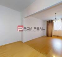 Predaj 3i, 74m2 bytu s výhľadom na Draždiak, Bratislava - Interiér 3-izbového bytu s laminátovou podlahou a závesmi na okne.