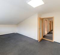 Príjemný dvojpodlažný RD 193 m2, klimatizácia, nezariadený, s garážou - Priestranná miestnosť s kobercom a sklenenými dverami v rodinnom dome.