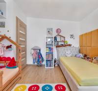Predaj 4 izbový dom.100 m2, pozemok 208 m2, Štúrova ul, Stupava - Detská izba v rodinnom dome s posteľami, poličkami a hračkami, svetlé drevené podlahy.