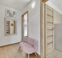 Predaj 4 izbový dom.100 m2, pozemok 208 m2, Štúrova ul, Stupava - Chodba v rodinnom dome s ružovou lavicou, zrkadlom a drevenými dverami.
