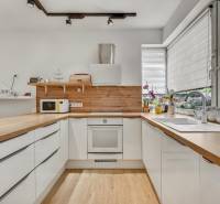 Predaj 4 izbový dom.100 m2, pozemok 208 m2, Štúrova ul, Stupava - Kuchyňa v rodinnom dome so svetlými skrinkami, drevenou pracovnou doskou a veľkými oknami.