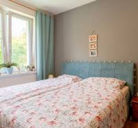 SVETLÝ – 3i s balkónom 69 m² – TOP lokalita Nová Dubnica - Spálňa s posteľou, závese v 3-izbovom byte a dreveným nočným stolíkom.