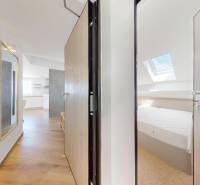 PAG/MANDRE - 2 apartmány za cenu jedného - 190m od mora - Interiér 4-izbového bytu s drevenou podlahou, zrkadlom a svetlou kuchyňou.