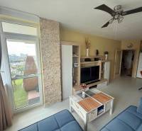 Moderný 2-izbový byt s terasou a výhľadom na mesto – Jégého alej, Nivy - Obývačka v 2-izbovom byte s balkónom, TV stenou a stropným ventilátorom.
