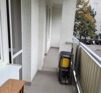 3-izb. byt, Mesačná ul., Ružinov, lodžia, 2.p./8 - Balkón v 3-izbovom byte so skladacími stoličkami a výhľadom na stromy v dvore.