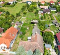 NA PREDAJ 38-ÁROVÝ STAVEBNÝ POZEMOK, BÁČ - Letecký pohľad na územie pre bývanie v Báči, obklopené zeleňou a domami.