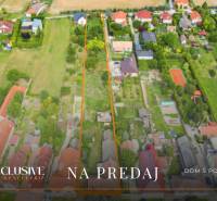 NA PREDAJ 38-ÁROVÝ STAVEBNÝ POZEMOK, BÁČ - Letecký pohľad na pozemky na bývanie v Báči s okolitými domami.