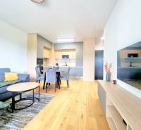 | EXKLUZÍVNE! | Krásny NOVÝ 2-izbový byt | 48m² | Čerešne - Obývacia izba v 2-izbovom byte s kuchyňou, jedálenským stolom a pohovkou.