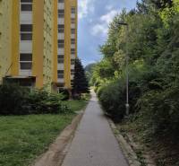 3i byt ul. Moskovská, Banská Bystrica - Žltý bytový dom na Moskovskej ulici v Banskej Bystrici vedľa chodníka a zelene.