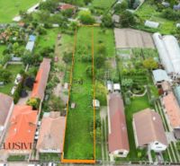 NA PREDAJ STAVEBNÝ POZEMOK - 1266 m², ROHOVCE - Letecký pohľad na úzky pozemok na bývanie v Rohovciach, ohraničený budovami a záhradami.
