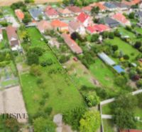NA PREDAJ STAVEBNÝ POZEMOK - 1266 m², ROHOVCE - Letecký pohľad na pozemky pre bývanie v Rohovciach, so zeleňou a susednými domami.