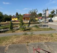 Dobré reality - Polyfunkčný objekt na predaj - Park a okolité budovy v Tekovských Lužanoch s kostolom v pozadí.