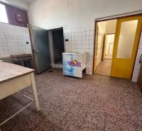 Dobré reality - Polyfunkčný objekt na predaj - Interiér budovy s dlažbou, stenami obloženými kachličkami a dreveným stolom.