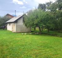 EXKLUZÍVNE - POZEMOK S GARÁŽOU V TURANOCH - Pozemok na bývanie v Turanoch so zeleným trávnikom a malou stavbou v záhrade.
